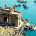 Gateway of India di Mumbai dengan latar laut biru dan perahu berwarna-warni, destinasi wisata populer di India