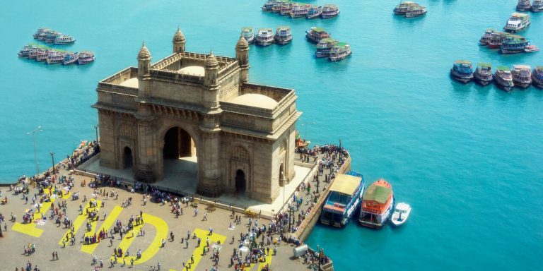 Gateway of India di Mumbai dengan latar laut biru dan perahu berwarna-warni, destinasi wisata populer di India