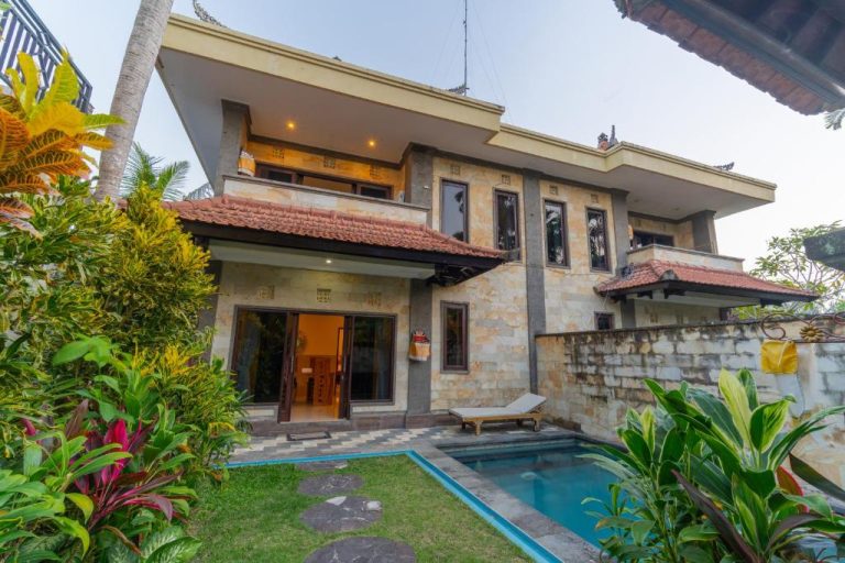 Bangunan villa luas dengan kolam renang kecil dan taman hijau di sekelilingnya