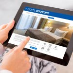 Ilustrasi pemesanan hotel online melalui tablet sebelum liburan