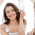 Perawatan kulit wajah dengan serum oleh wanita muda untuk menjaga kesehatan dan kecantikan kulit sejak dini.