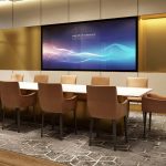 Ruang meeting hotel modern dengan meja panjang, kursi ergonomis, proyektor, dan whiteboard untuk pertemuan bisnis profesional.
