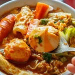 Seblak Bandung dengan kerupuk, telur, dan bumbu pedas menggugah selera, hidangan khas yang memanjakan lidah dengan rasa pedas dan gurih